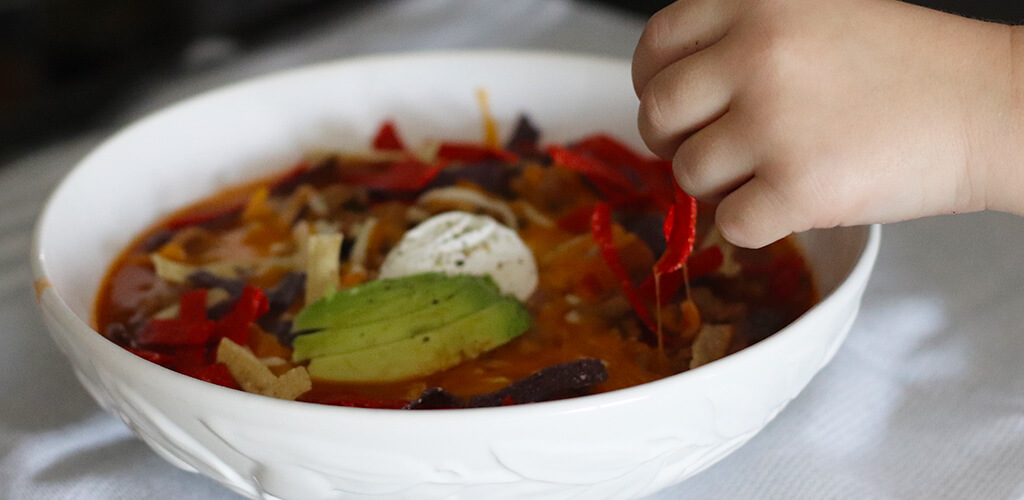 sliced peppers, mushrooms, beans, and spices on a cutting board.