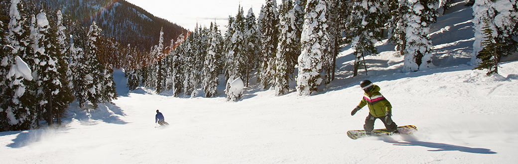 two people snowboarding downhill